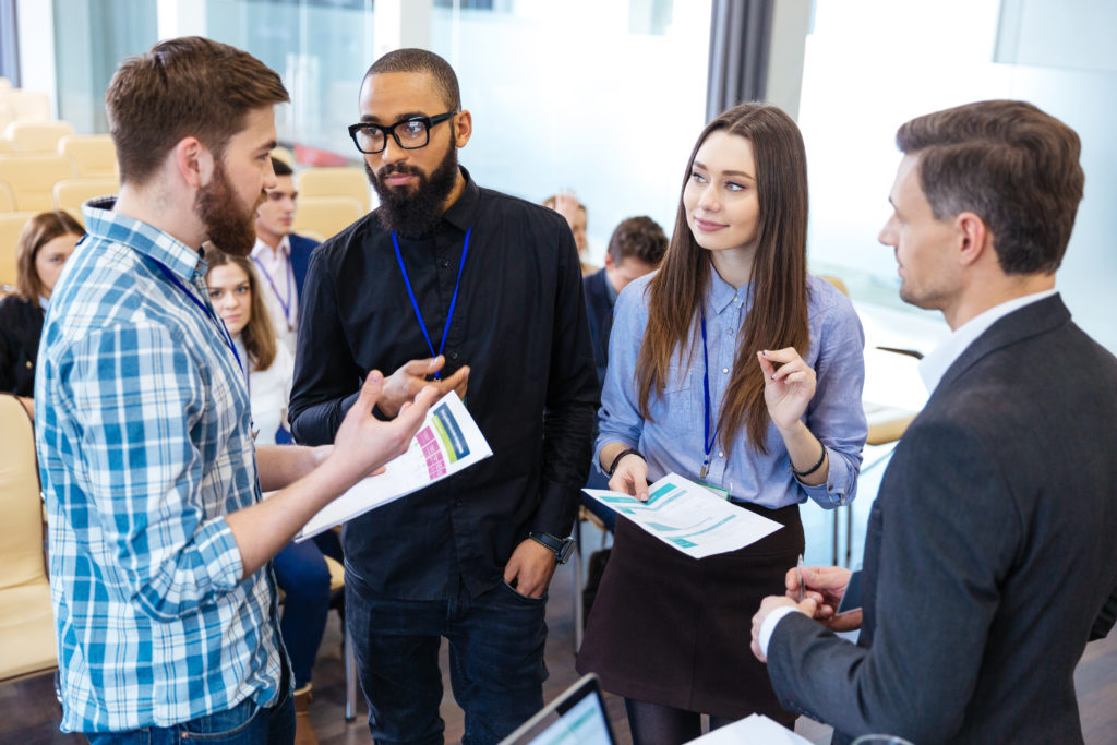 Confident business people standing and discussing financial report in office