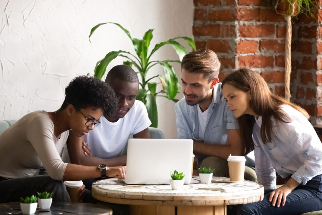 African American woman with friends using laptop