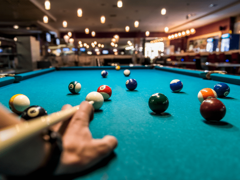 A man playing pool in a pool hall