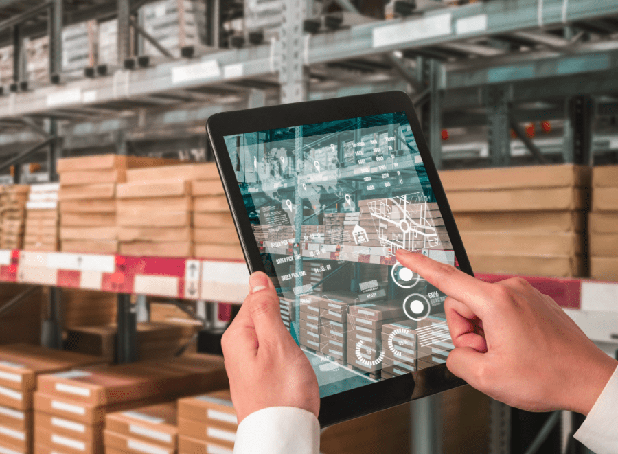 Person holding a tablet out in front of them touching the screen as if doing inventory in a warehouse