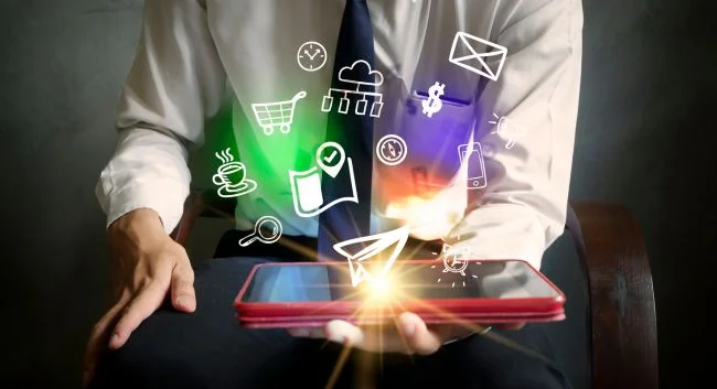 Composite image showing person holding a mobile device with software-related icons floating over it.